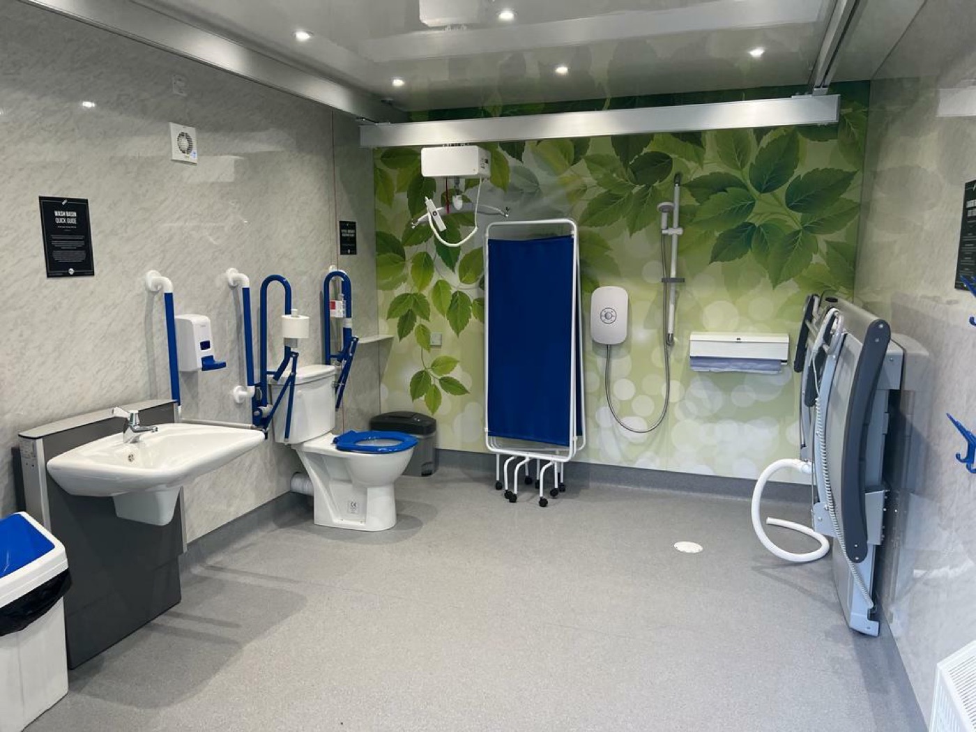 A Changing Places facility with a ceiling hoist and an adult changing bench