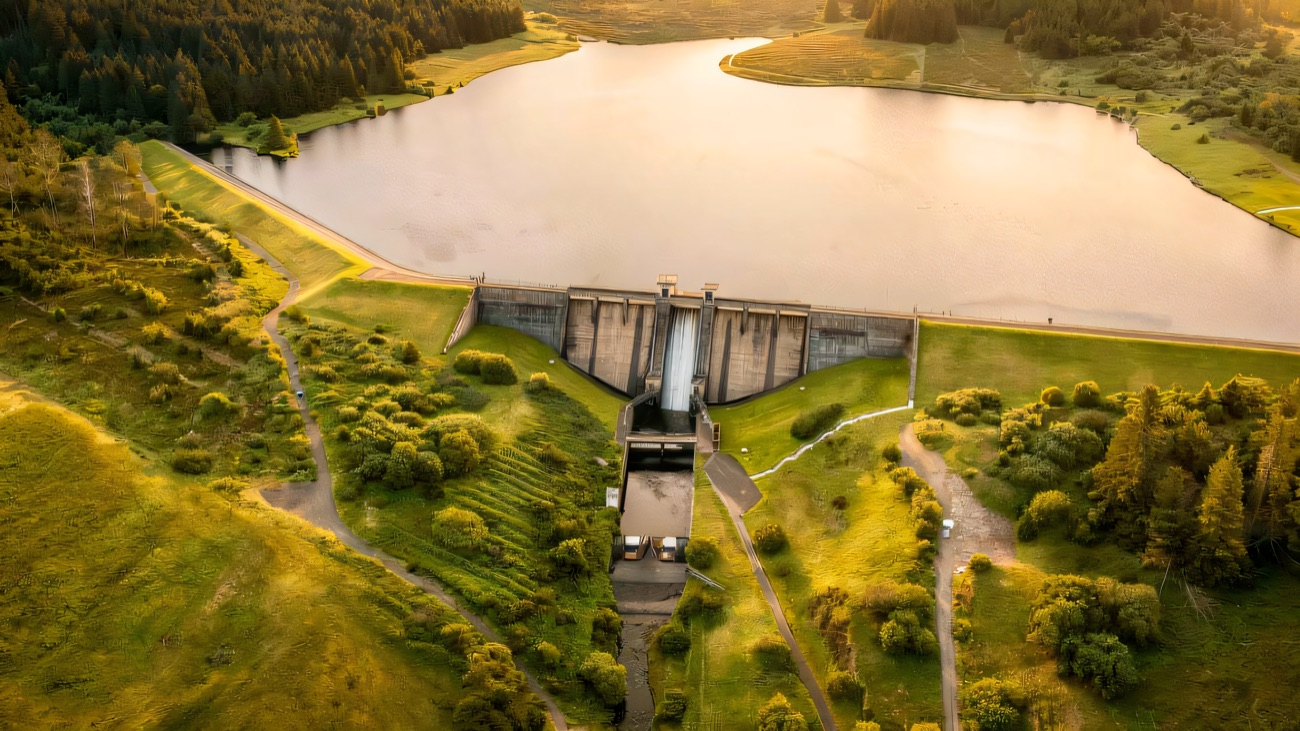 The reservoir and its dam wall ringed by forestry from the air