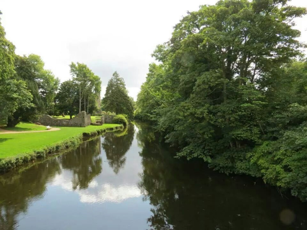 The Six Mile Water flowing calmly through the wooded grounds past the garden lawns