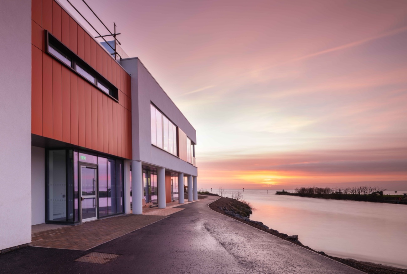 Sunset over Lough Neagh with the shore and the Gateway building in the foreground