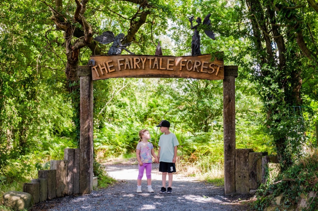 The carved wooden Fairytale Forest entrance arch over a woodland path