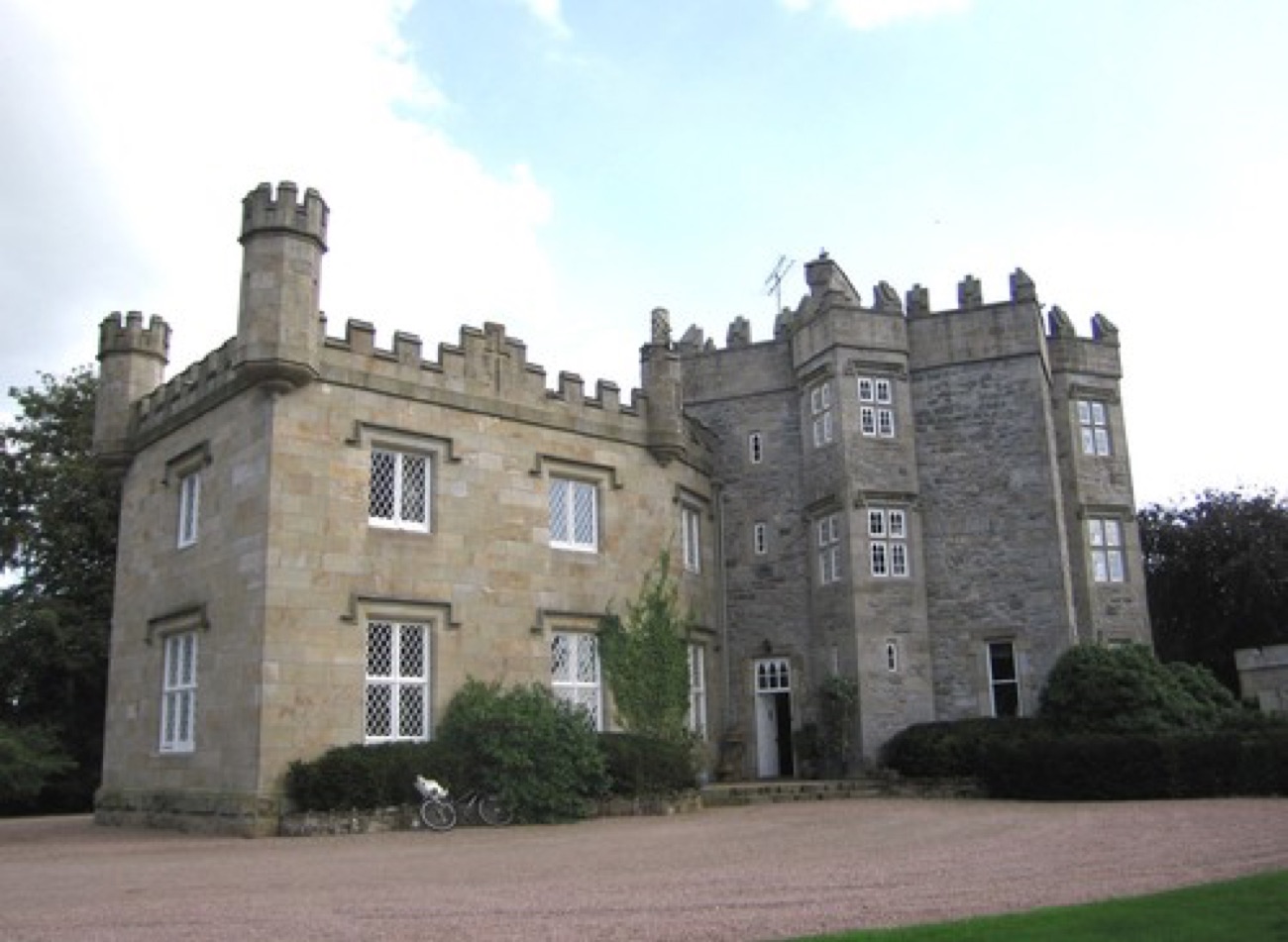 Augher Castle, the restored castellated stone house with its battlemented towers, seen from the forecourt