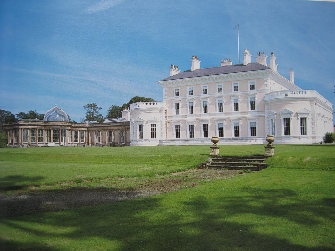 Ballywalter Park mansion seen from the side with its long domed conservatory wing to the left and stone garden urns