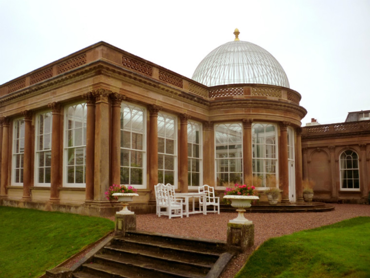 The domed sandstone conservatory at Ballywalter Park, ringed by columns with garden urns and steps in front