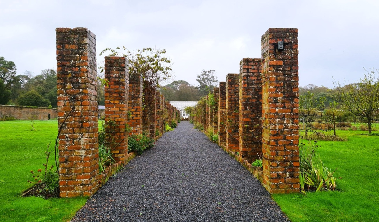 A gravel path running between tall brick pillars in the walled garden at Ballywalter Park
