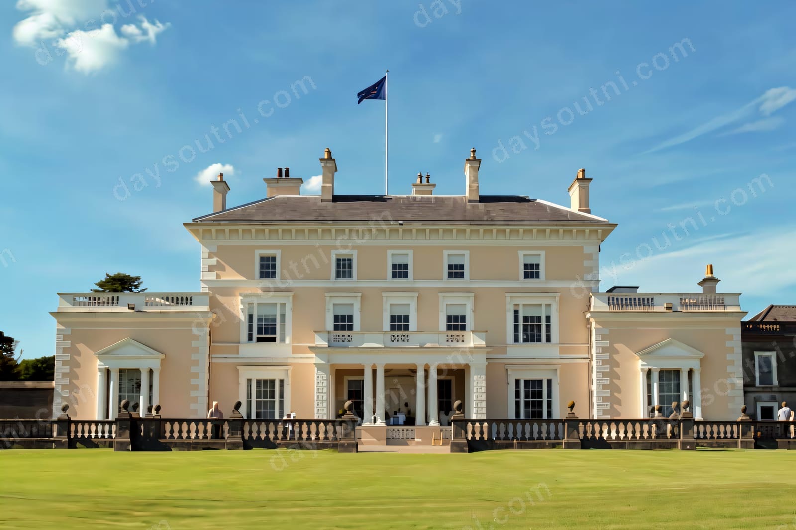 The Italianate front of Ballywalter Park, a cream stucco mansion with a balustraded terrace above green lawn