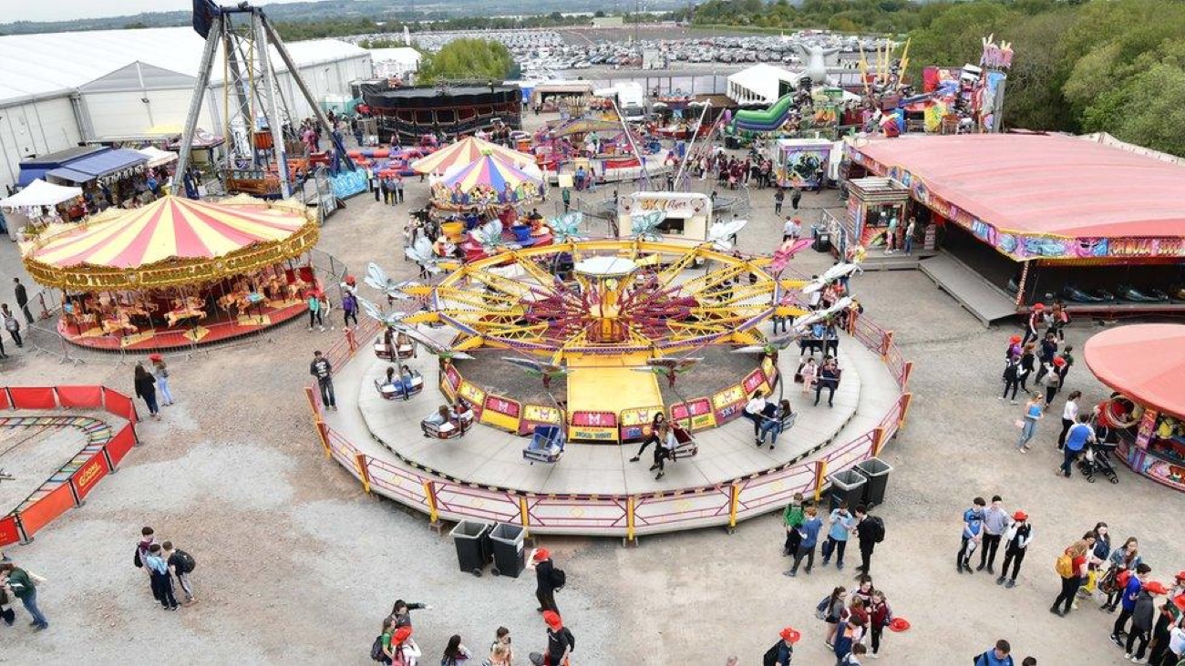 The Balmoral Show funfair from above — carousel, waltzer and rides with families walking between them
