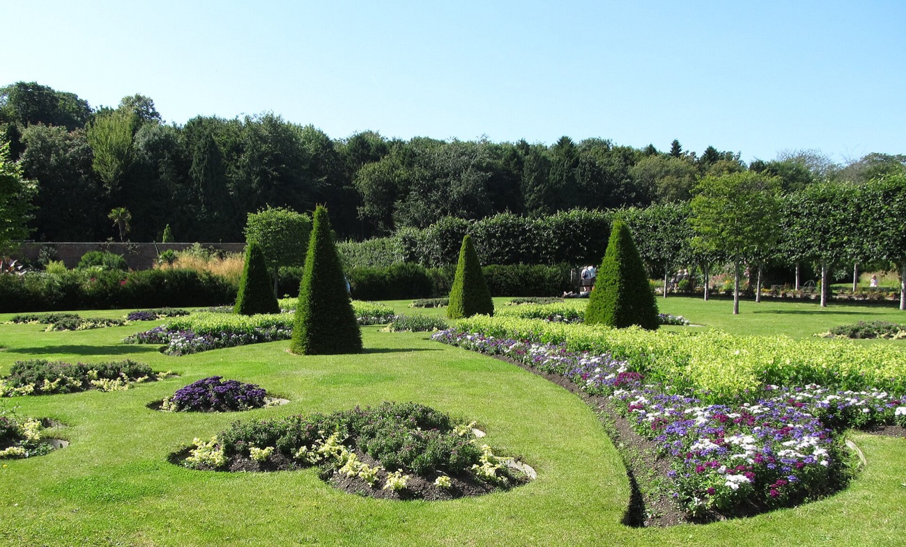 The formal lawn, topiary cones and ornamental beds of the walled garden