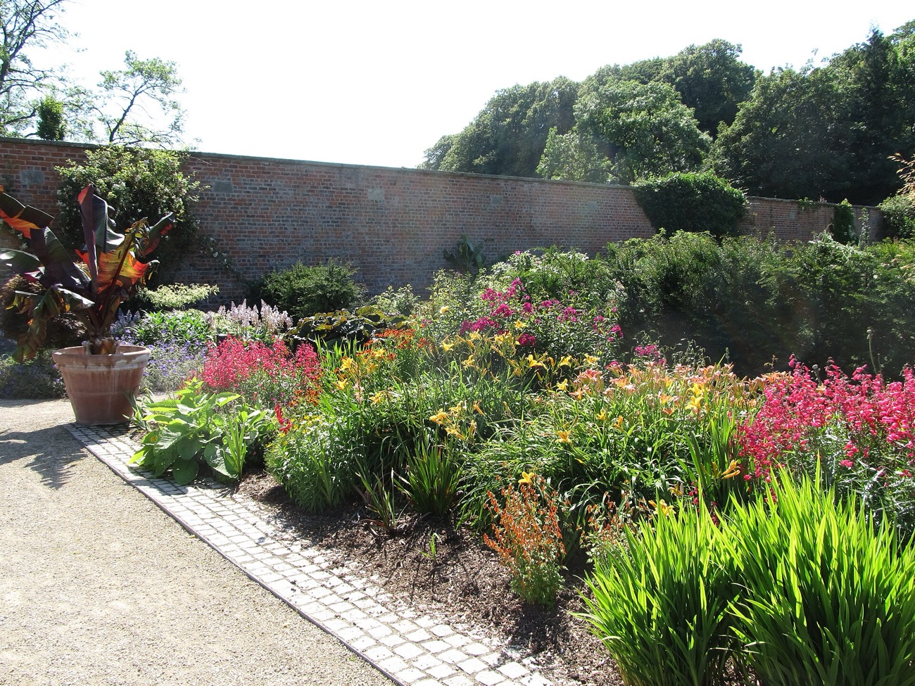 Herbaceous flower borders against the old brick wall