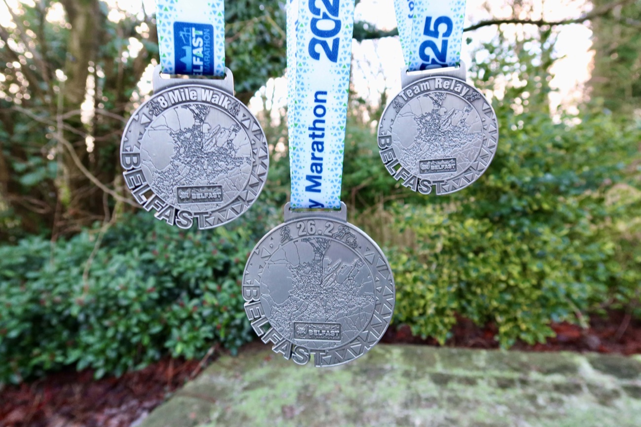 The Belfast City Marathon medals for the marathon, team relay and 8-mile walk hanging on ribbons
