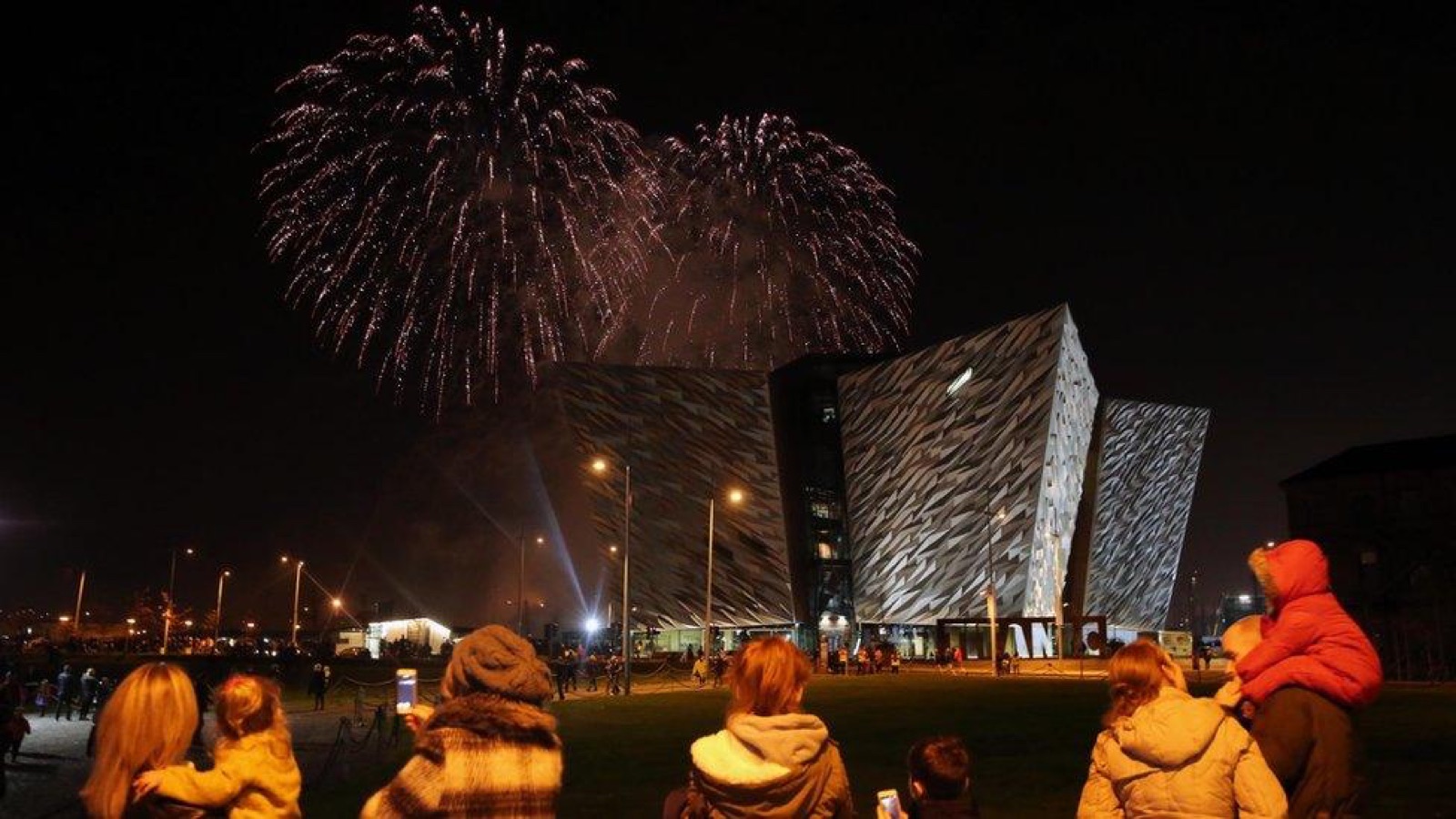 Fireworks bursting over Titanic Belfast as crowds watch the Belfast Halloween Monster Mash at the Titanic Slipways
