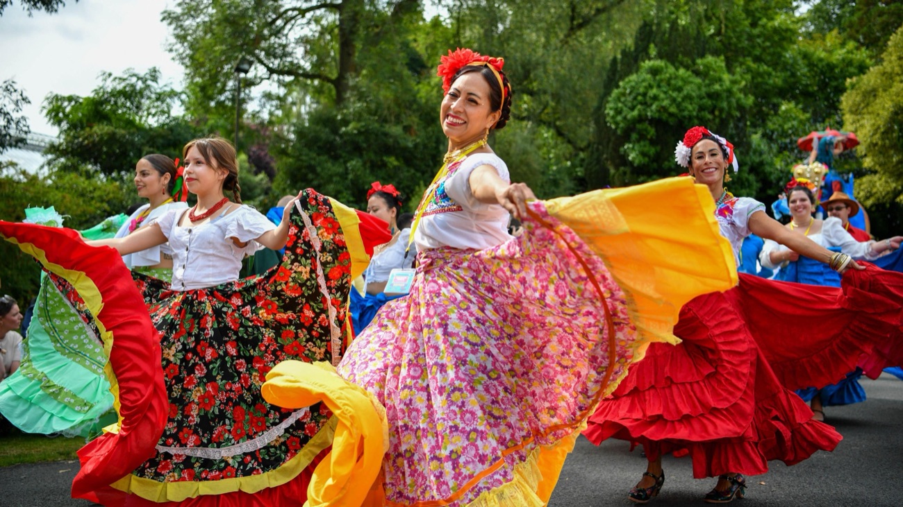 Colourful folk dancers performing in the green of Botanic Gardens at Belfast Mela