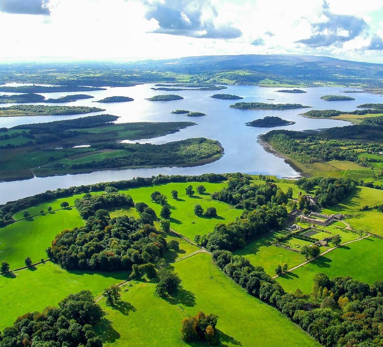 An aerial view of Upper Lough Erne, a maze of green islands and drumlins in a wide silver lough