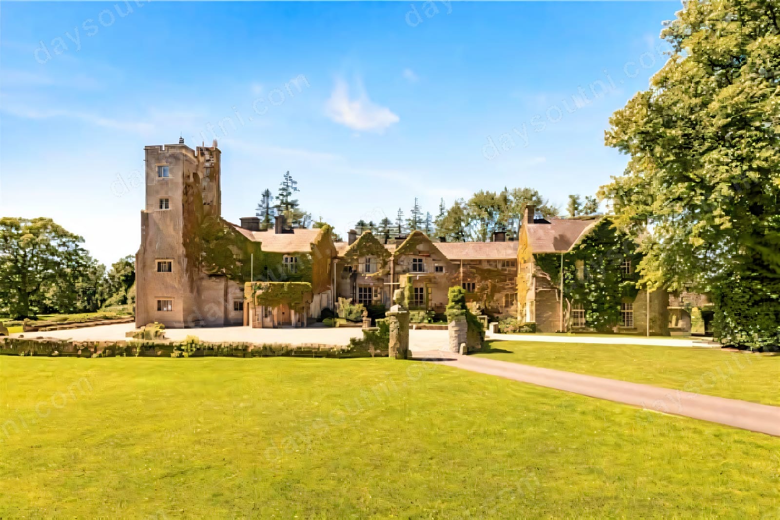 Belle Isle Castle, a stone house with a tall tower, above green lawns and mature trees