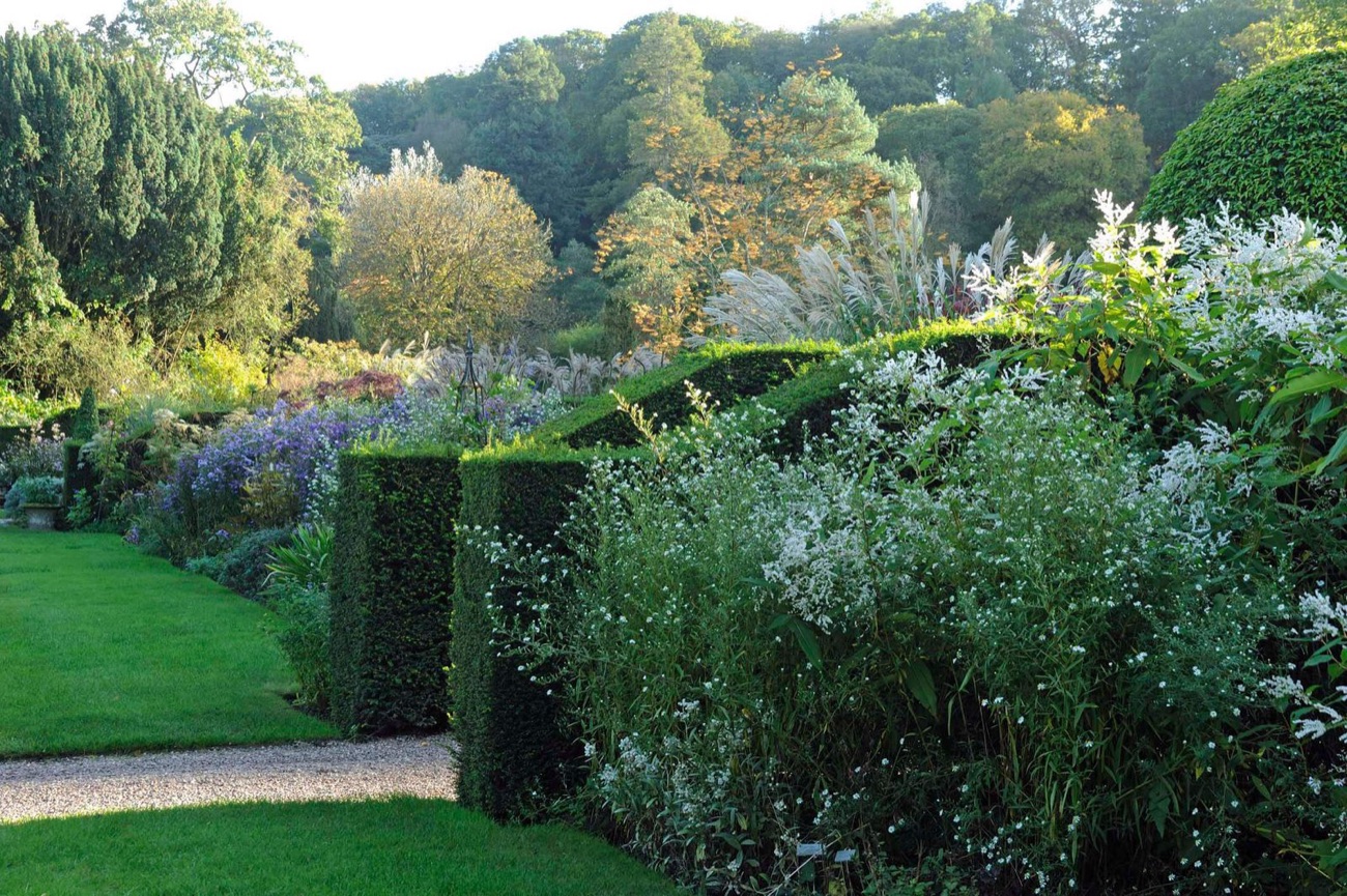 Deep mixed borders framed by clipped yew hedges