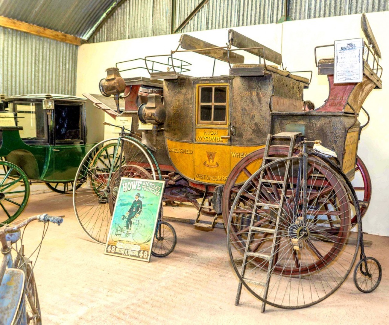 Old horse-drawn coaches and penny-farthing bicycles in the Carriage & Costume Museum