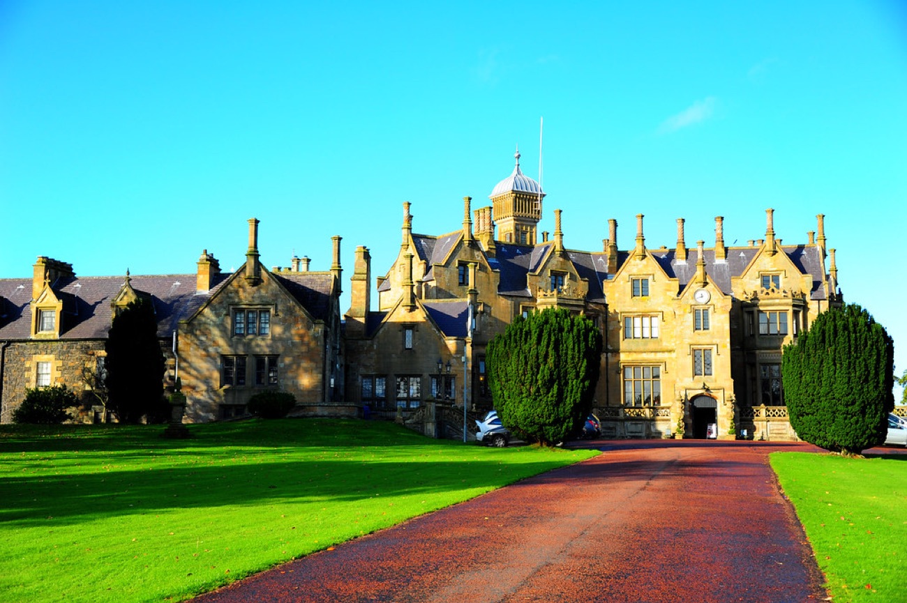 The long drive approach to Brownlow House showing the full sandstone mansion and its central lanterned tower