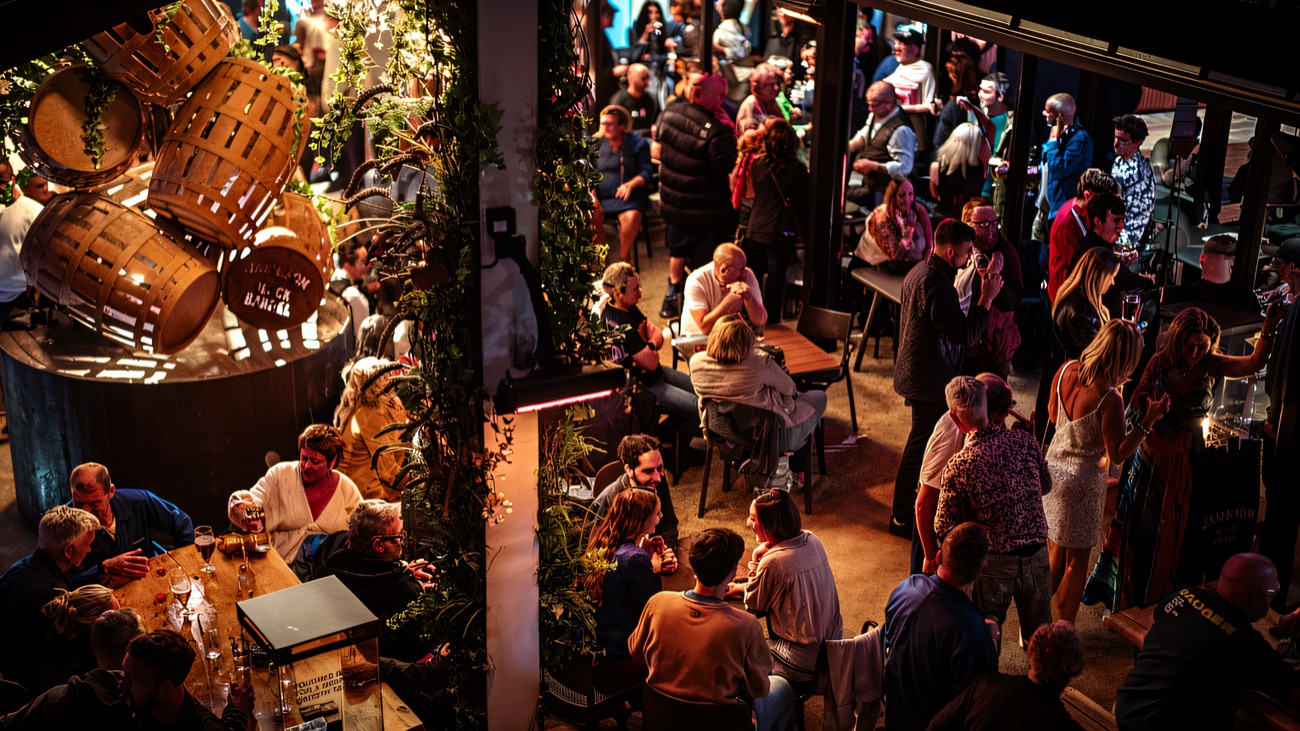 Busy bar room seen from above, with booth seating and a long counter