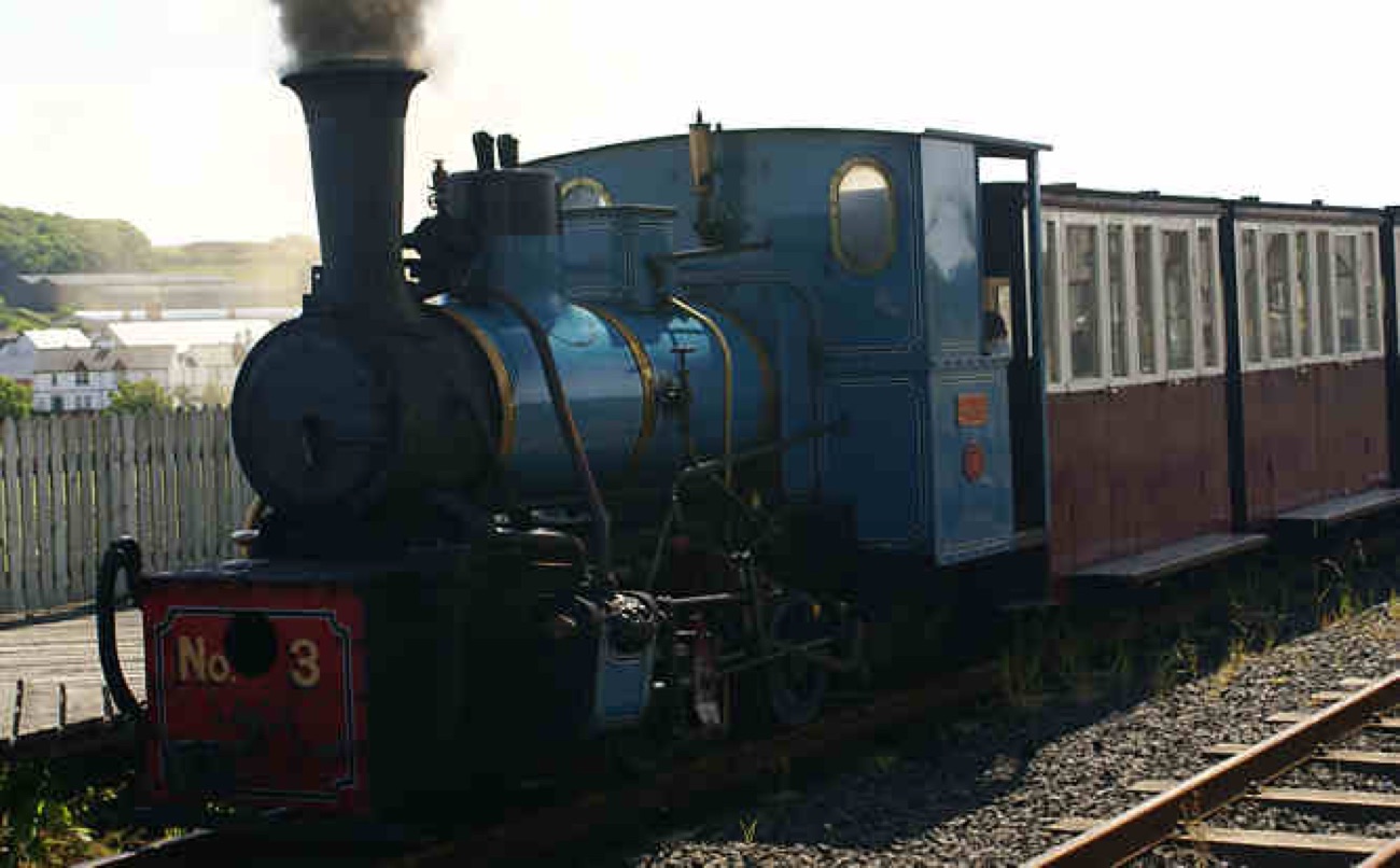 The blue steam locomotive No 3 close up, steaming and backlit
