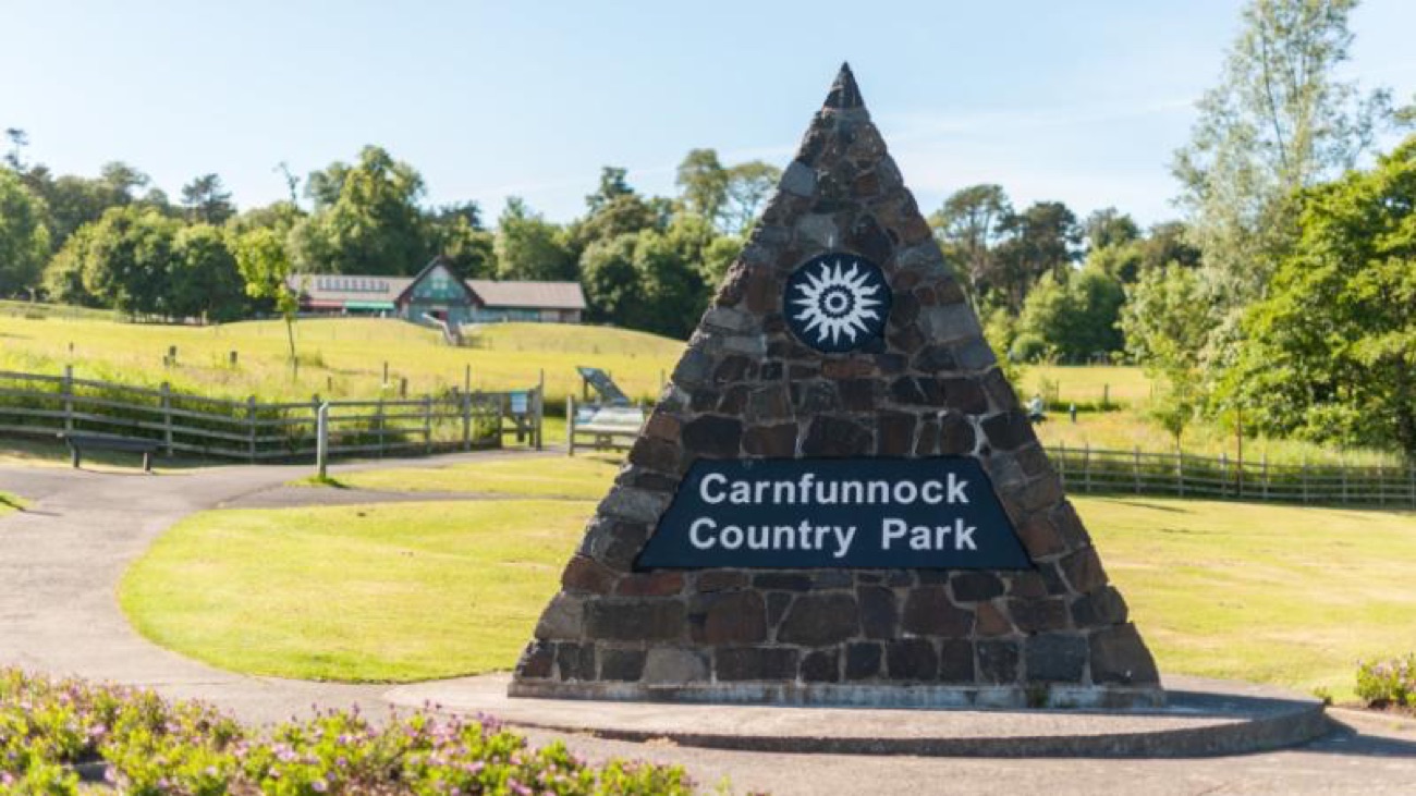 The stone pyramid entrance marker at Carnfunnock Country Park on the lawn, with the visitor buildings behind and trees around