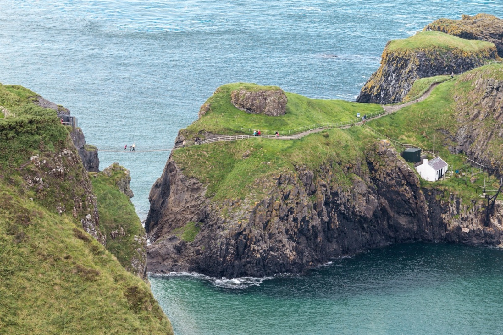 The Carrick-a-Rede rope bridge, island and turquoise sea seen from above