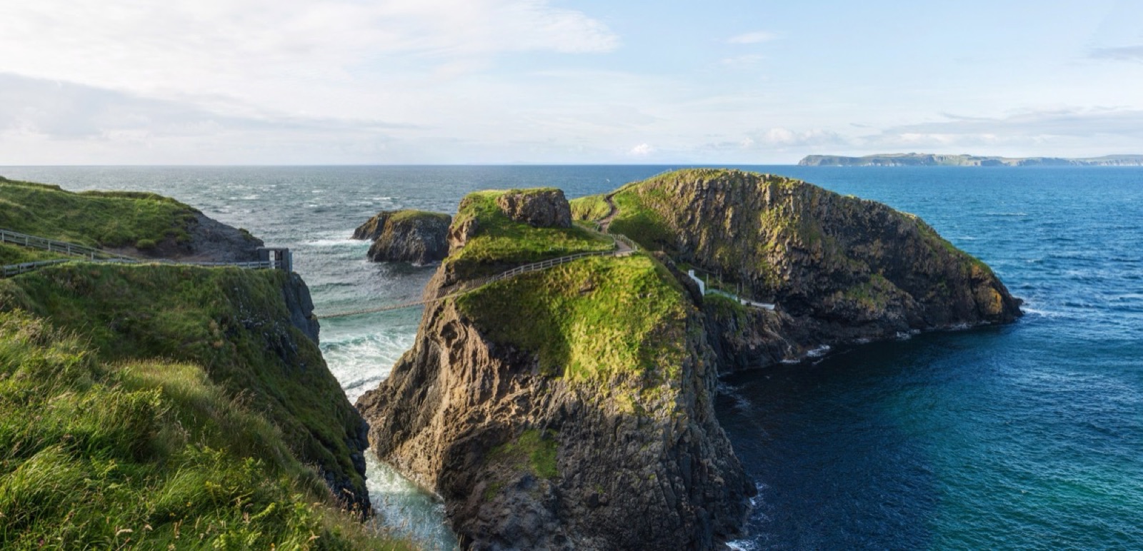 The island and cliffs at Carrick-a-Rede in a wide coastal view