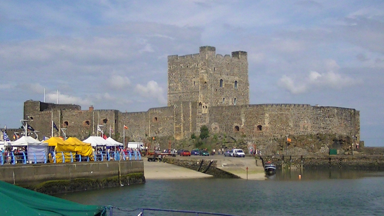 Carrickfergus Castle, the grey Norman keep and curtain walls, seen across the harbour on a bright day