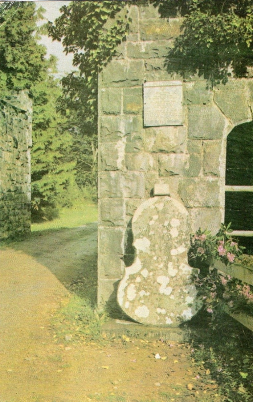 The Fiddlestone at Castle Caldwell — a fiddle-shaped stone set against the gateway with an inscribed plaque above it