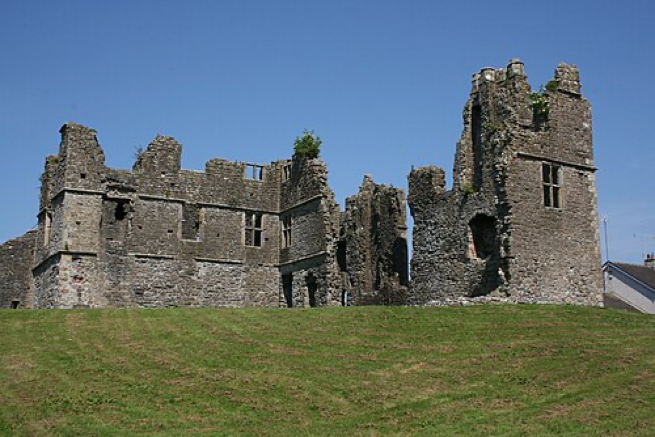 The full ruined manor house of Castle Caulfield on its grassy mound at the edge of the village