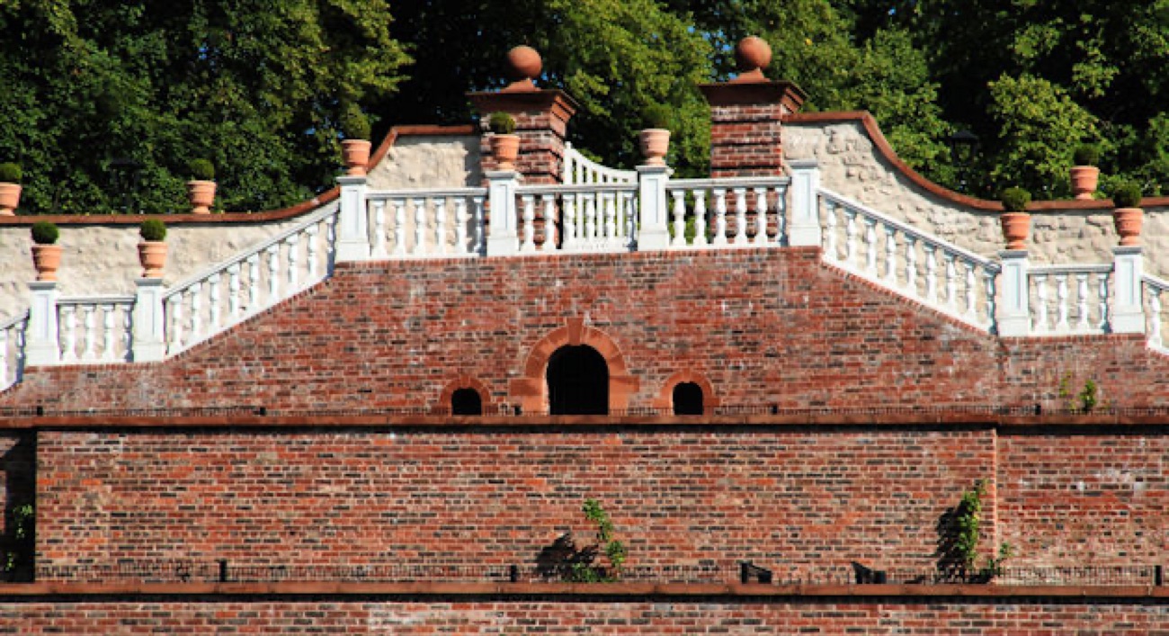The double-flight brick and stone perron staircase at Castle Gardens with balustrade and stone urns