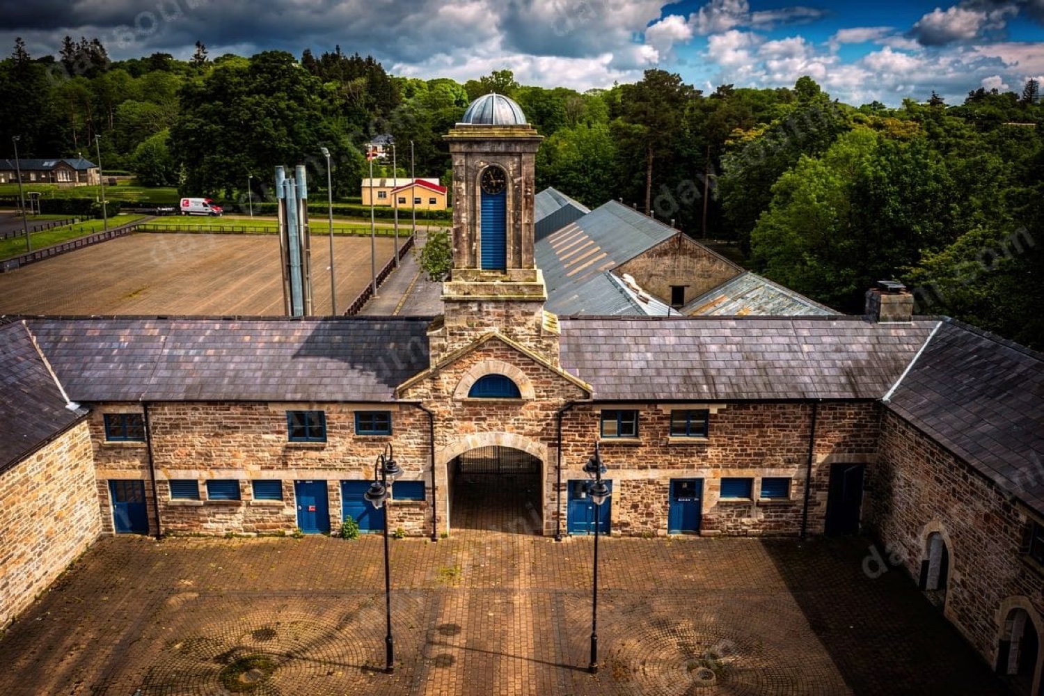 The stone stable-yard and clock tower at Necarne Estate (Castle Irvine) near Irvinestown, with a cobbled courtyard