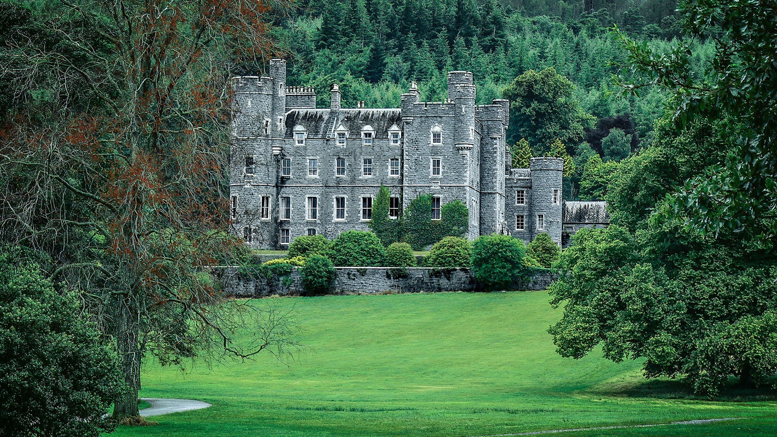 Castlewellan Castle framed by trees above a green lawn