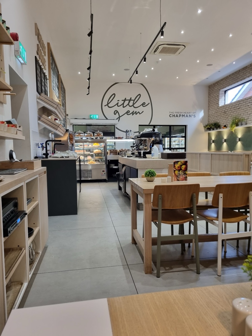 Inside the Little Gem café at Chapman's, pale wood tables and the counter beneath the Little Gem sign