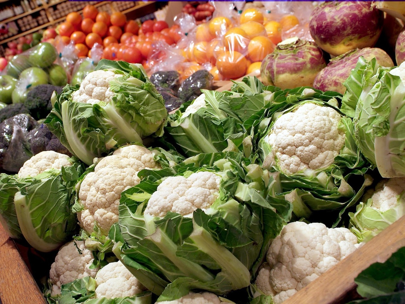 Cauliflowers, tomatoes and salad piled on the fresh produce display