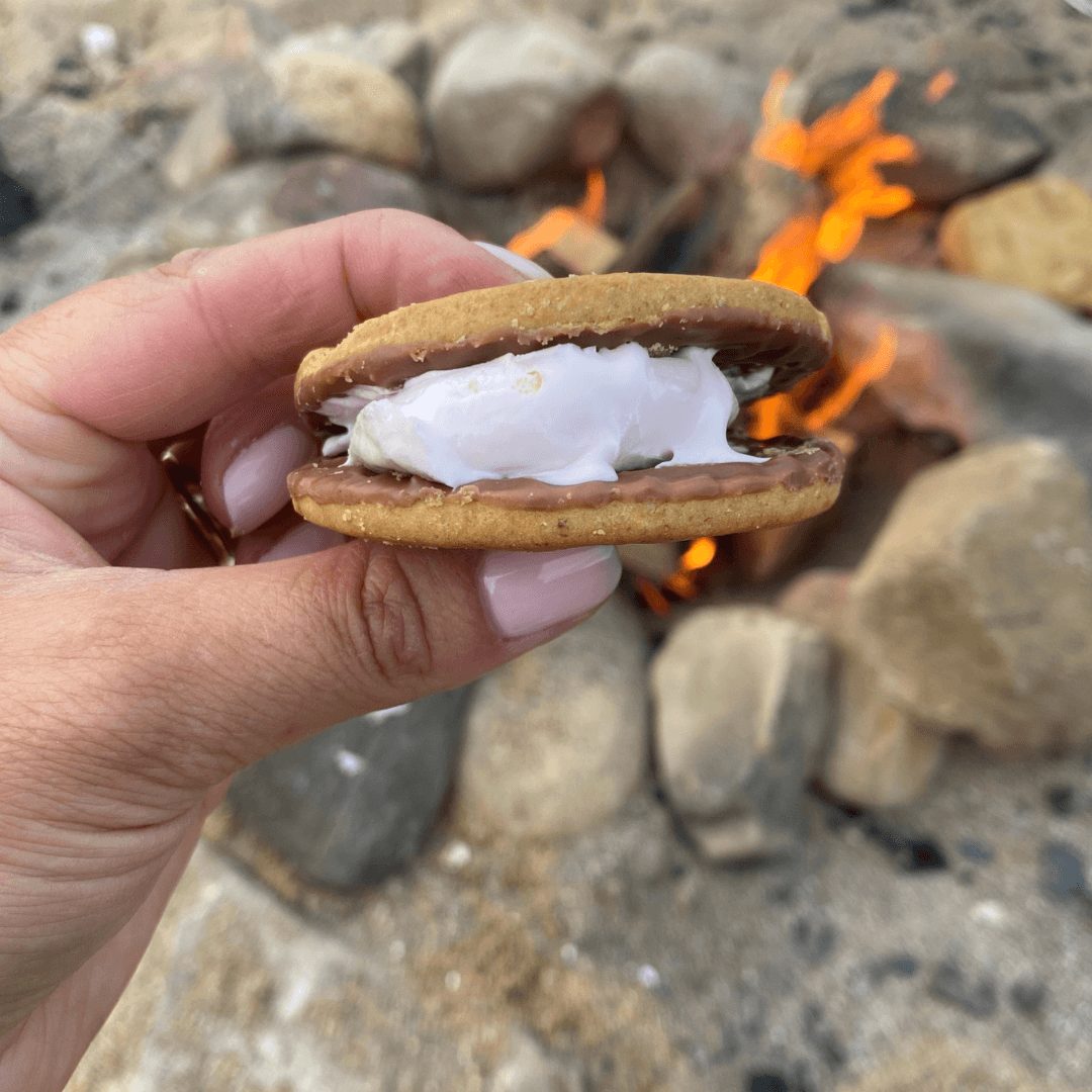 A gooey toasted-marshmallow s'more held over the campfire at the Festive Forest