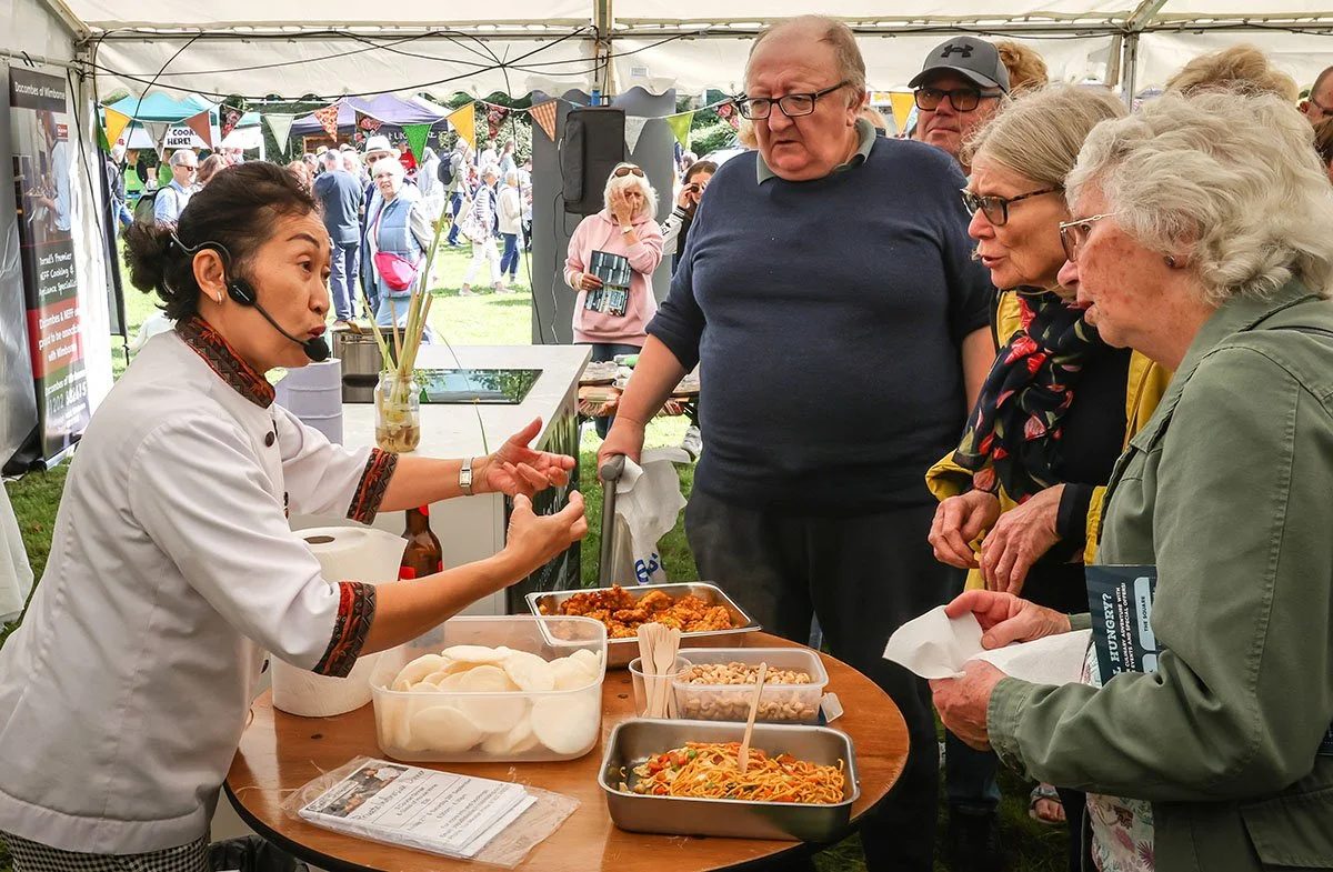 A cook serving fresh food to visitors at a stall at the food festival
