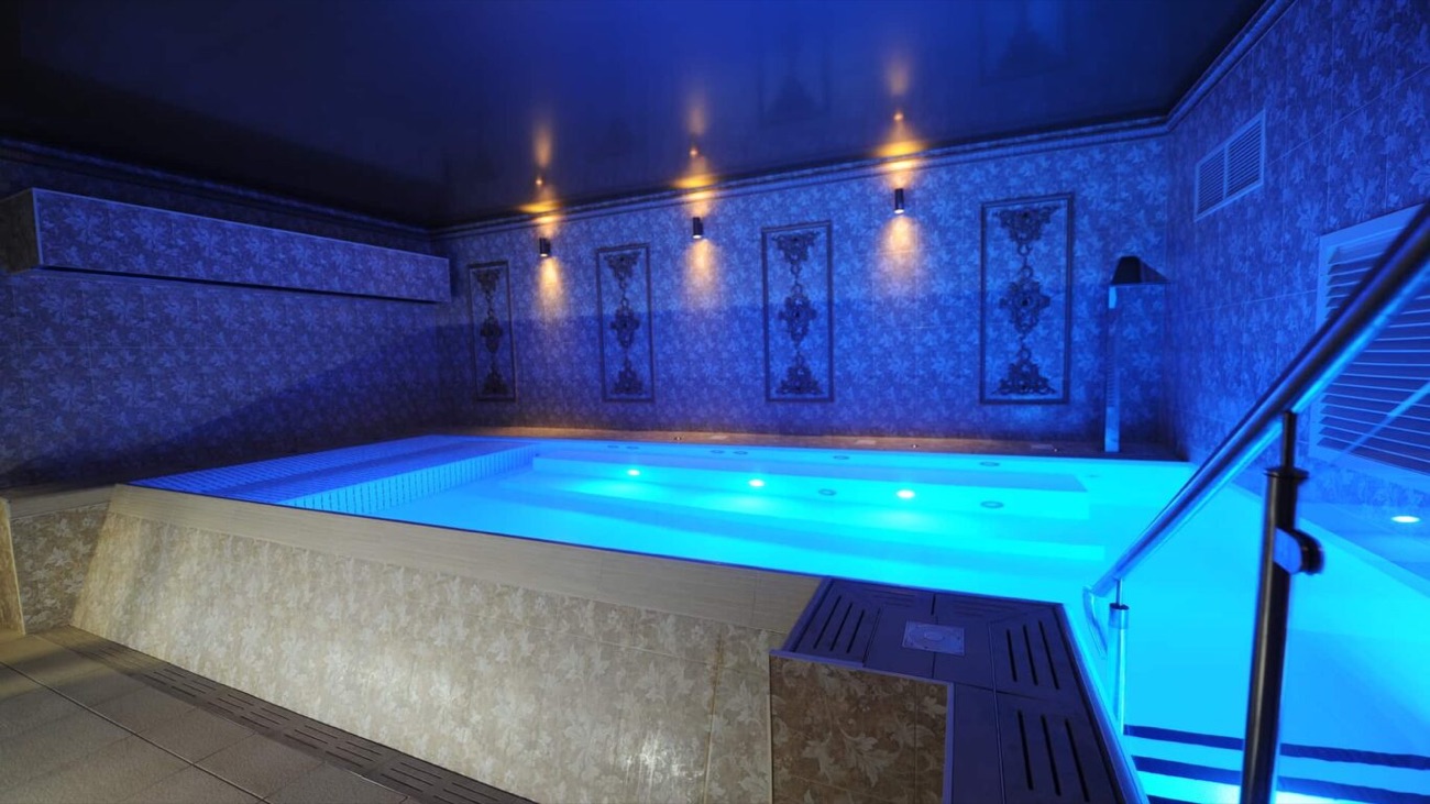 The hydrotherapy pool lit deep blue, jets bubbling along the far wall.