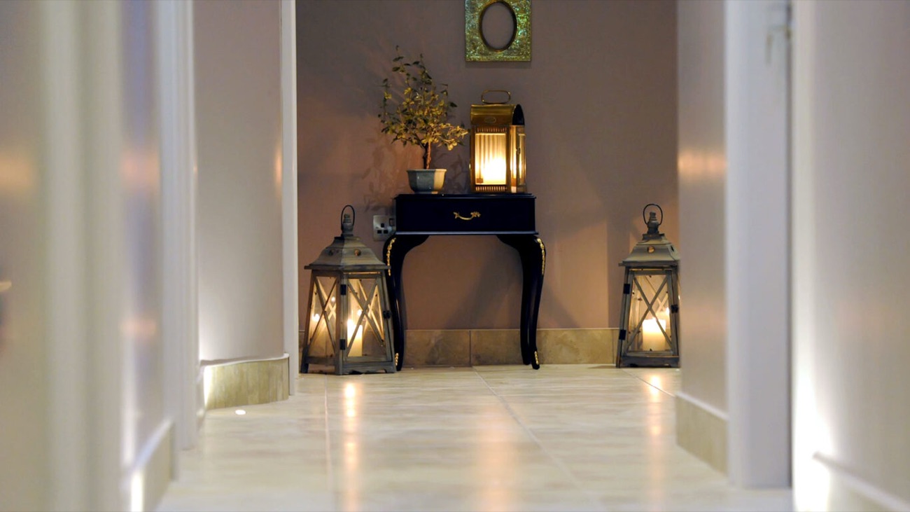 A candle-lit spa corridor with lanterns and a soft, quiet glow.