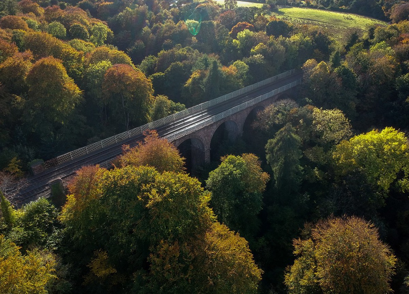 The old stone railway viaduct at Crawfordsburn crossing the wooded glen in autumn colour