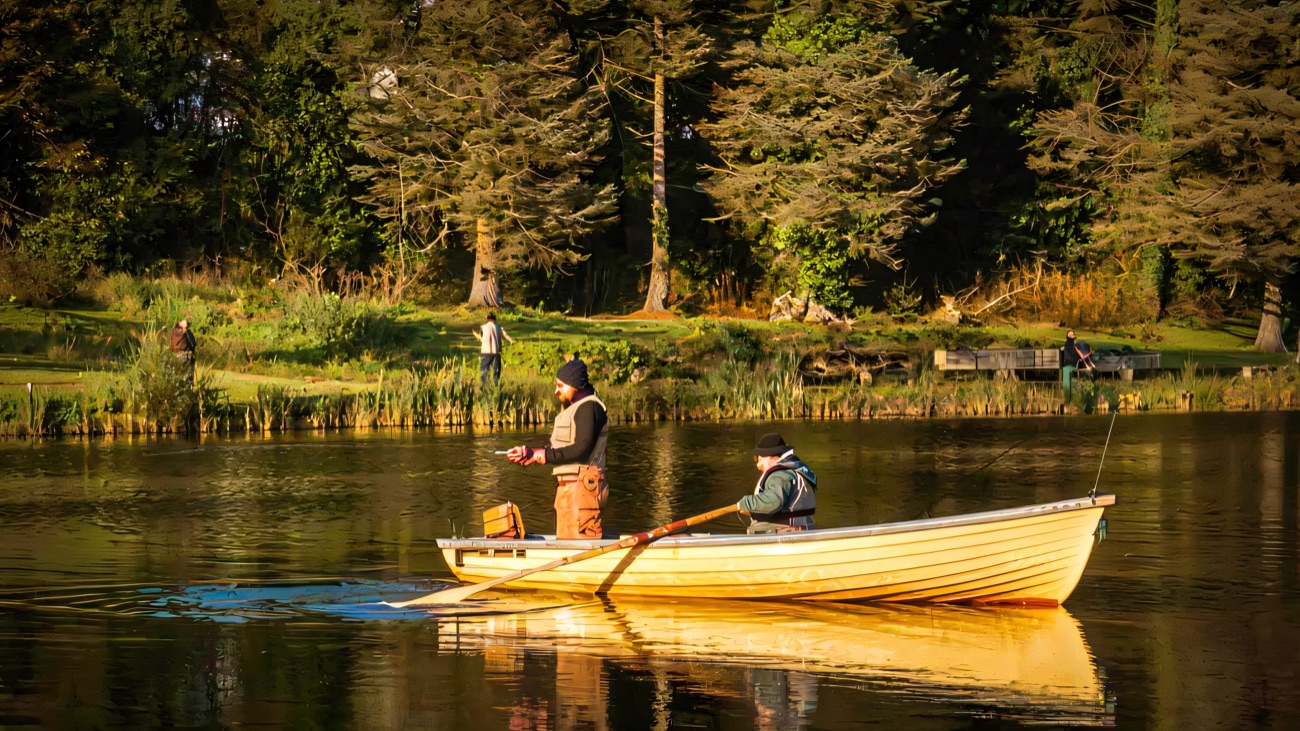 Boat and bank anglers fishing the trout lake together