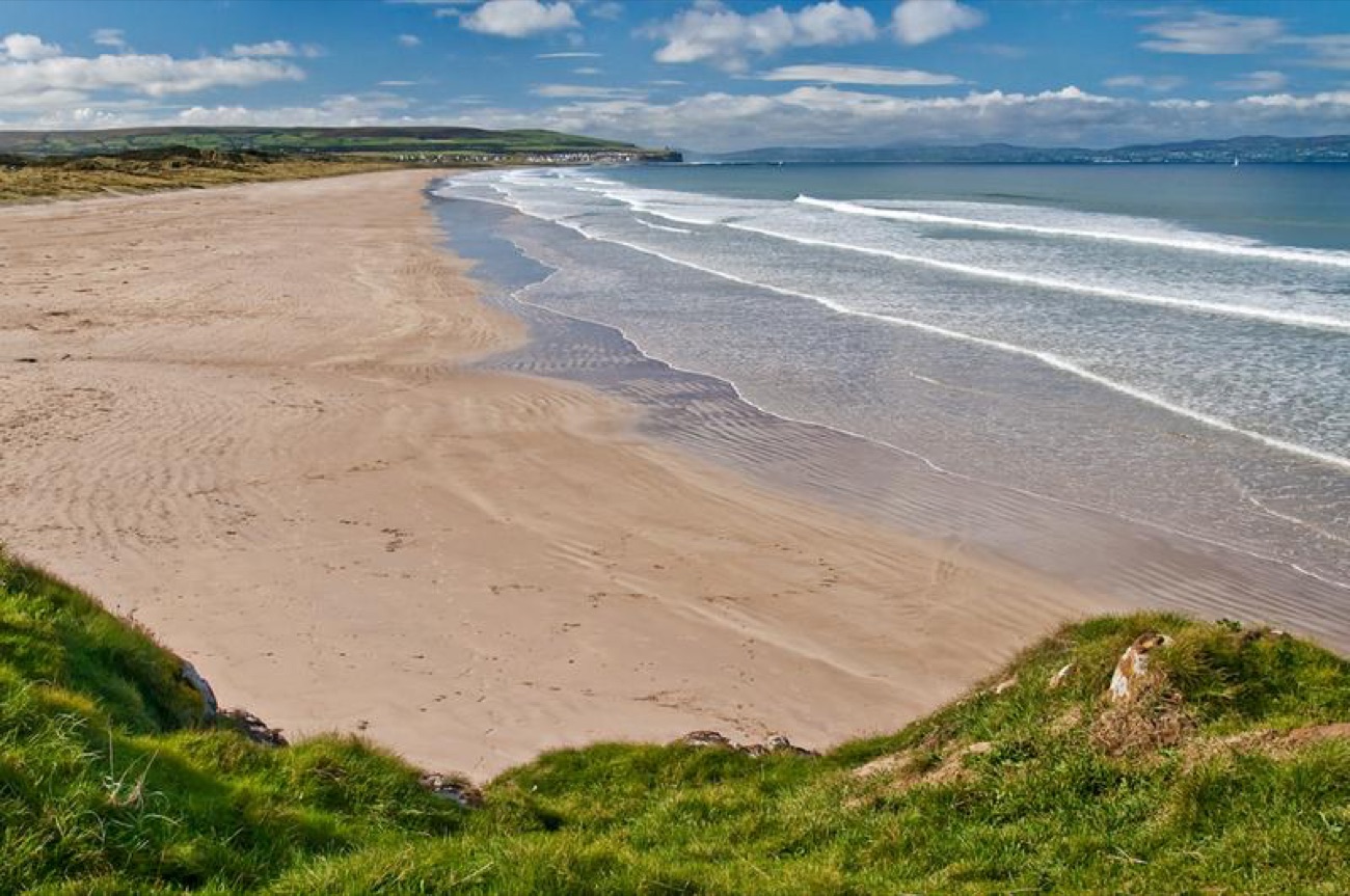 The wide golden sweep of Portstewart Strand nearby, the sea coming in against green dunes