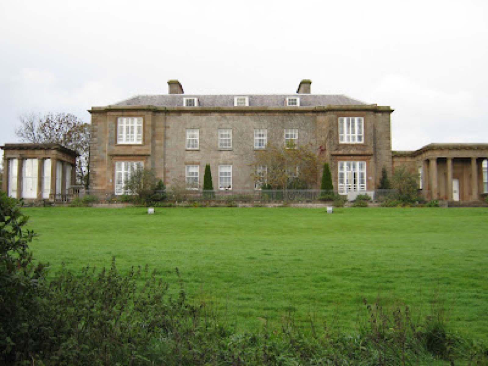 Cromore House across its parkland lawn, flanked by two colonnaded garden porches