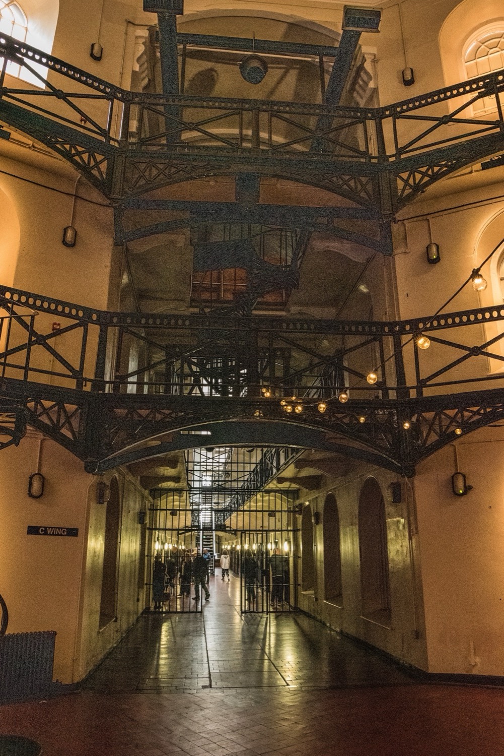 The great Victorian C-wing atrium at Crumlin Road Gaol, with tiered iron walkways and hanging lamps