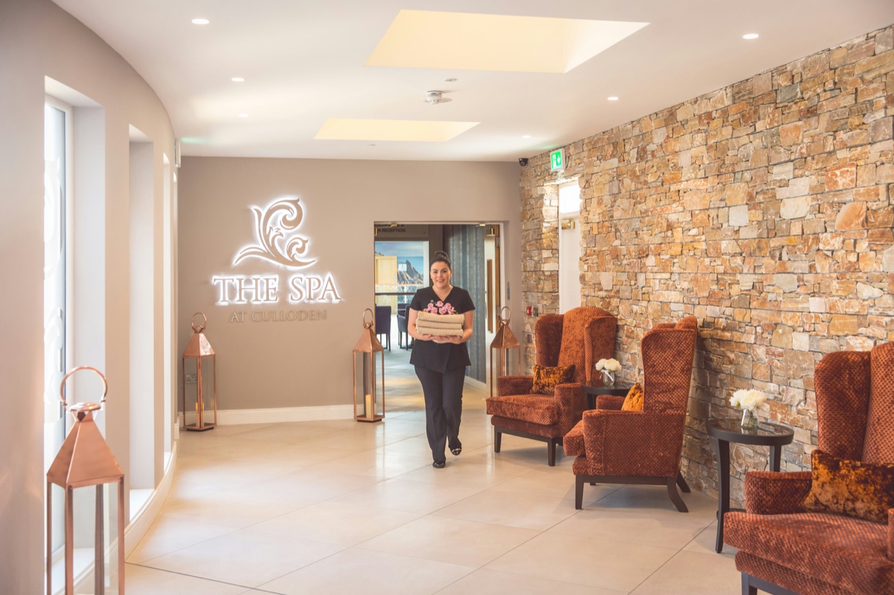 The warm-stone spa reception, with deep armchairs and soft lighting.