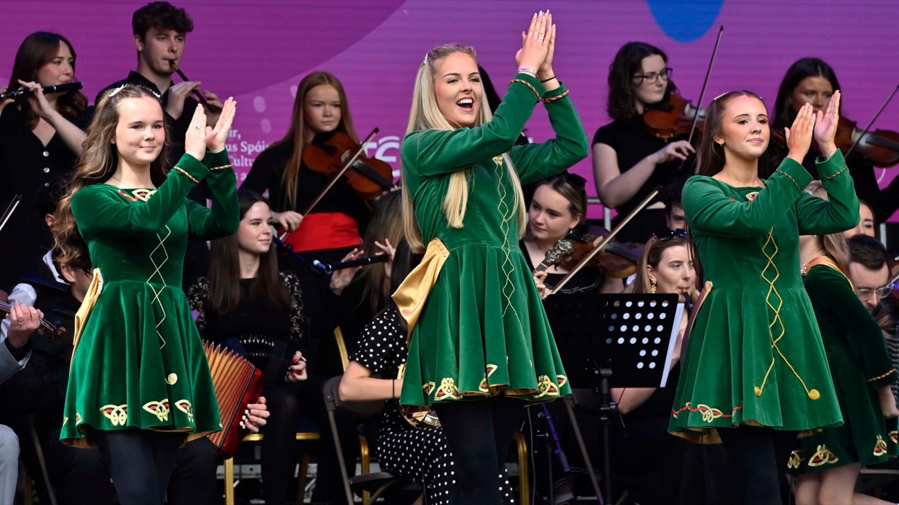 Traditional Irish dancers in green performing with a live trad orchestra