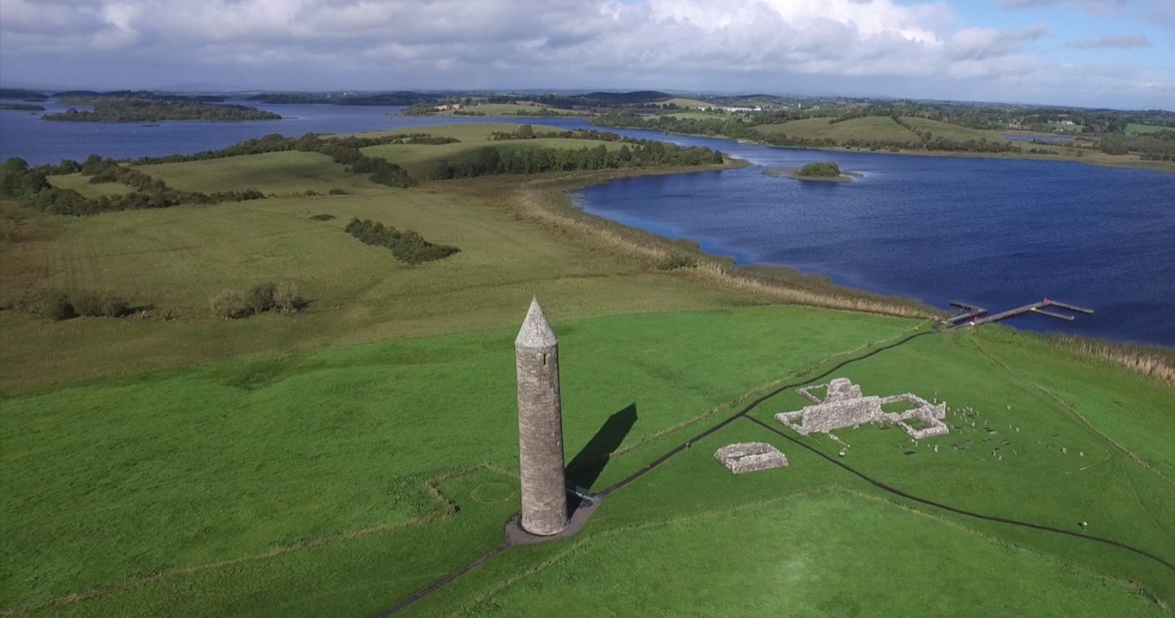 Aerial view of the round tower and ruins on the green island of Devenish, ringed by Lough Erne