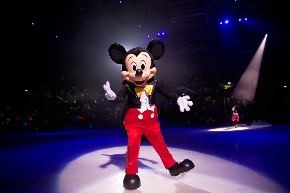 Mickey Mouse skating in the spotlight during a Disney On Ice performance