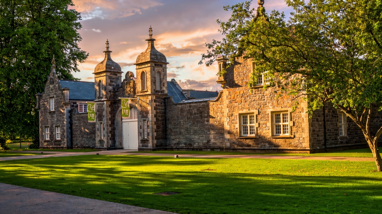 Clotworthy House at Antrim Castle Gardens glowing in evening light across the lawn
