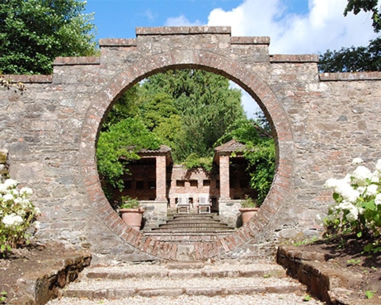 The circular stone moon gate of the Moon Garden looking through to the garden beyond