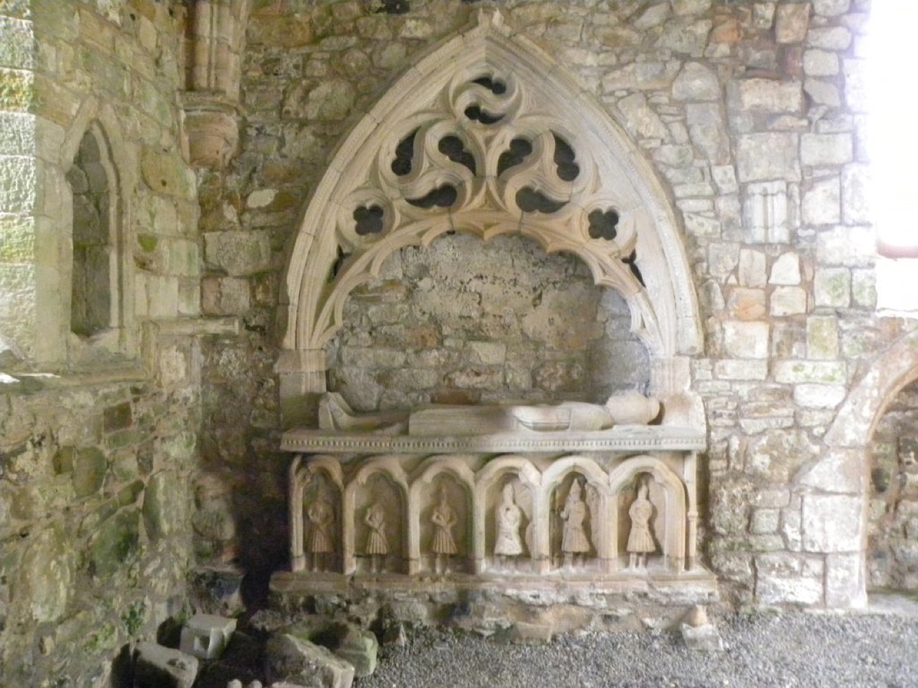 The medieval O'Cahan tomb in Dungiven Priory, a carved effigy under a gothic canopy above six kilted warrior figures